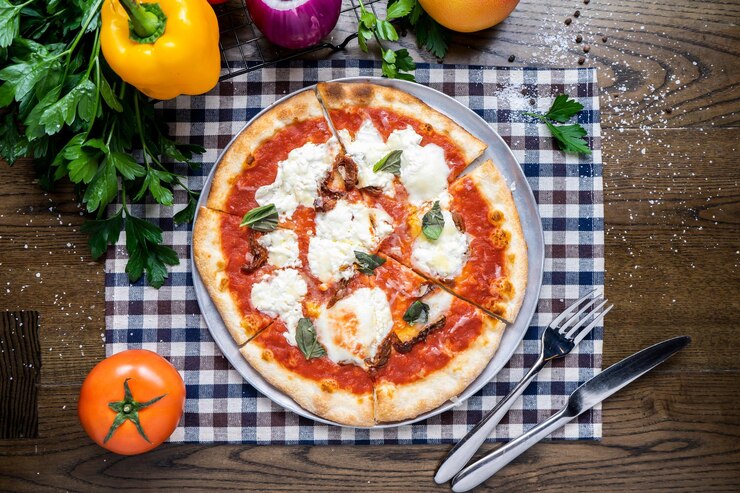 Foto margherita pizza con pomodoro cipolla capsicum coriandolo coltello e forchetta servito in piatto isolato su tovagliolo vista superiore del fast food italiano su tavolo di legno