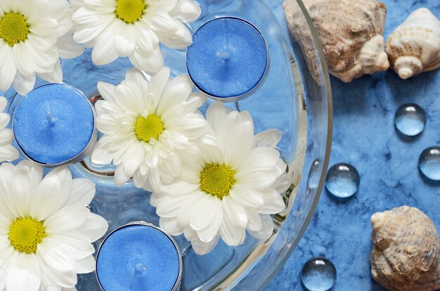 Margherite e candele nell'acqua sopra il mare