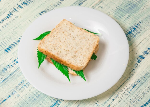 Marijuana e cibo Un panino con foglie di marijuana L'uso della cannabis nella produzione di alimenti Il concetto di aumentare l'appetito dopo aver consumato marijuana