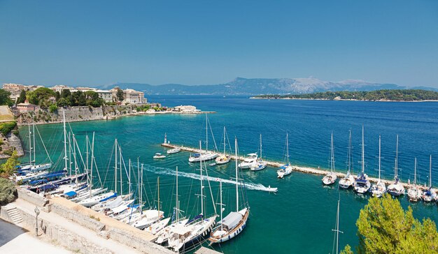 Marina con yacht ormeggiati e centro storico. Vista dalla vecchia fortezza di Kerkyra (città di Corfù), isole ioniche, Grecia.