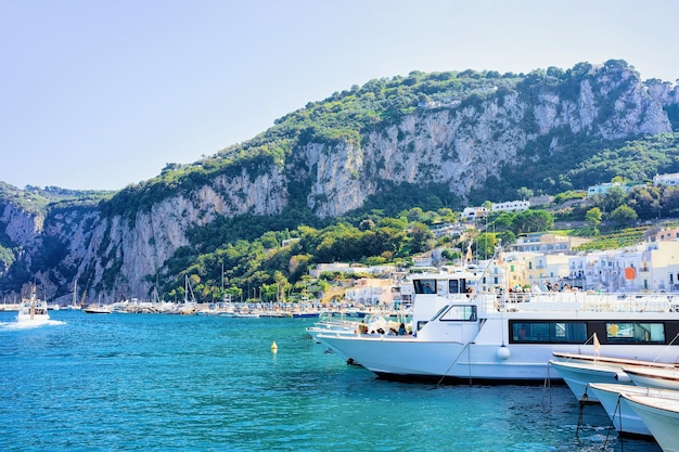 Marina con yacht sulla città dell'isola di Capri a Napoli in Italia. Paesaggio con Mar Mediterraneo blu sulla costa italiana. Anacapri in Europa. Vista sui Faraglioni in estate. Paesaggio amalfitano e monte Solaro