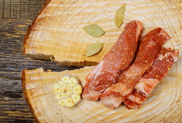 Marinare la carne con le spezie sulla tavola di legno