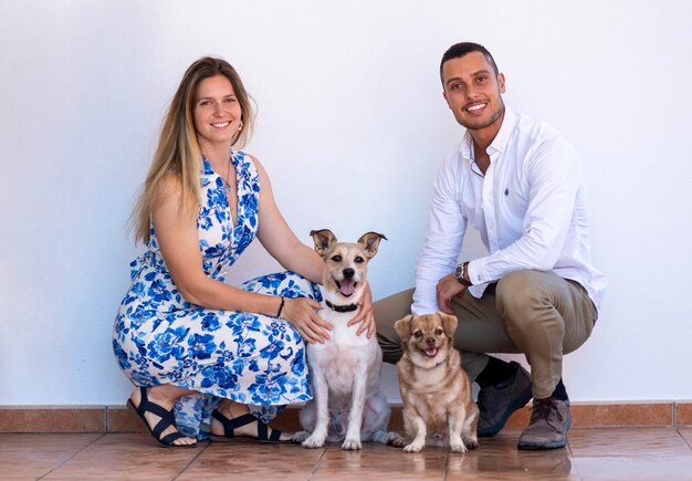 Marito e moglie con due cuccioli di cane su uno sfondo bianco