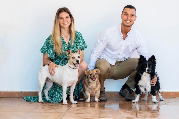 Marito e moglie con tre cuccioli di cane su uno sfondo bianco