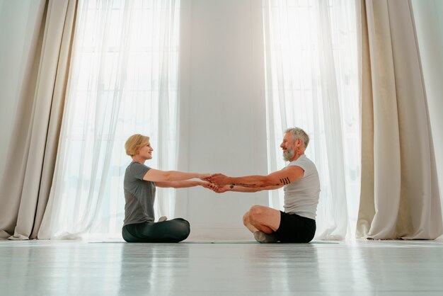 Marito e moglie fanno esercizi di yoga insieme a casa