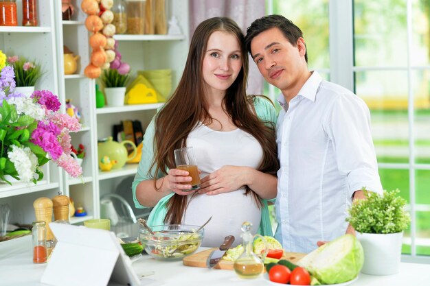 Marito e moglie felici che cucinano insieme in cucina