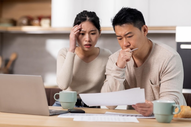 Marito e moglie giapponesi confusi che controllano le loro spese