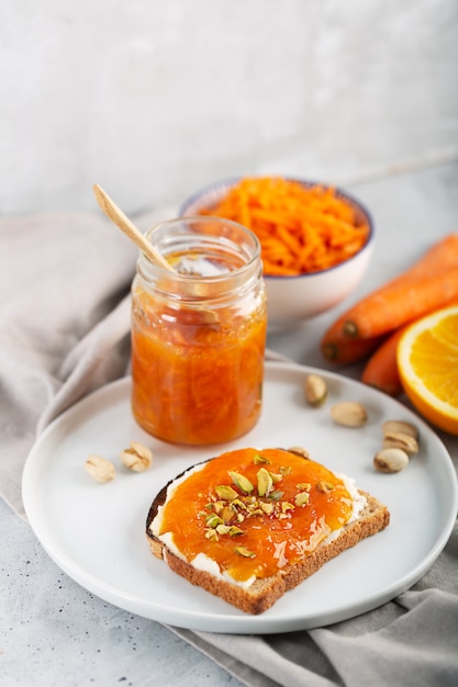 Marmellata di carote con succo d'arancia su uno sfondo grigio