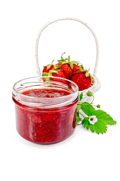 Marmellata di fragole in un barattolo di vetro con fragole in un cesto di vimini bianco, foglie di fragola e fiori isolati su sfondo bianco