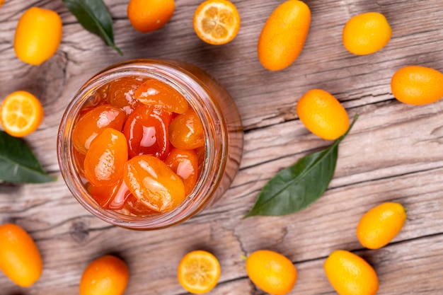 Marmellata di kumquat fatta in casa in barattolo e kumquat freschi, vista dall'alto