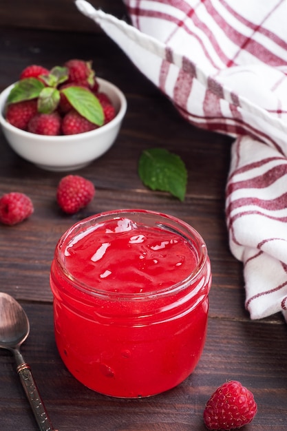 Marmellata di lamponi fatta in casa in un barattolo di vetro e lamponi freschi alla menta