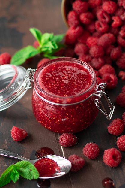 marmellata di lamponi in un barattolo di vetro su un tavolo di legno