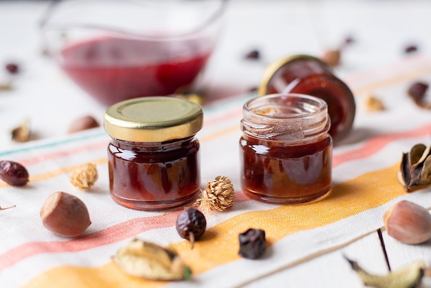 Marmellata di lamponi sul tavolo un vasetto di marmellata rossa su un tessuto chiaro