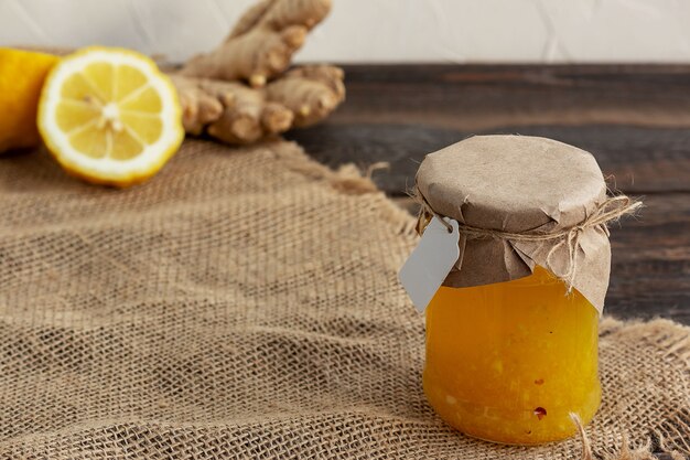 Marmellata di limone e zenzero in un barattolo di vetro su fondo di legno wooden