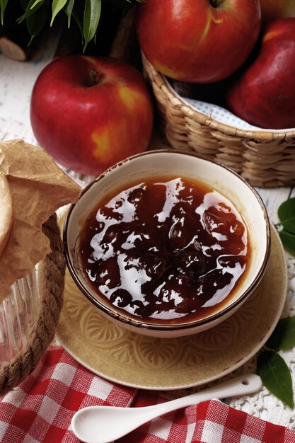 Marmellata di mele e mele rosse fresche sul primo piano della tavola di legno