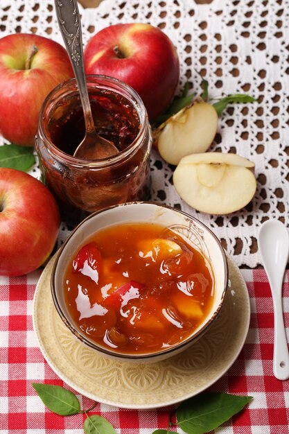 Marmellata di mele e mele rosse fresche sul primo piano della tavola di legno