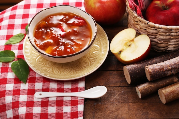 Marmellata di mele e mele rosse fresche sul primo piano della tavola di legno