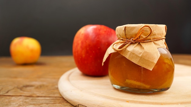 Marmellata di mele in un vasetto di vetro trasparente marmellata di mele su fondo di legno