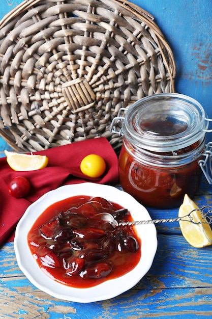 Marmellata di prugne casalinga saporita in piatto bianco sul primo piano di legno della tavola