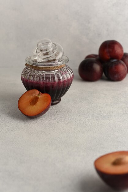 Marmellata di prugne in una ciotola di vetro. Marmellata naturale fatta in casa in vaso di vetro e frutta fresca di prugne.