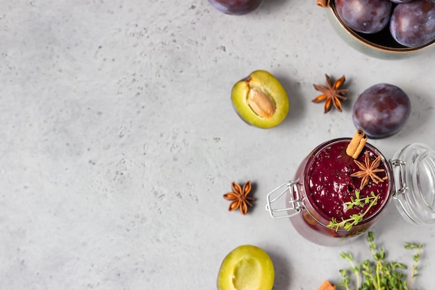 Marmellata di prugne piccante fatta in casa dolce, frutta, timo e spezie sul tavolo di pietra grigia