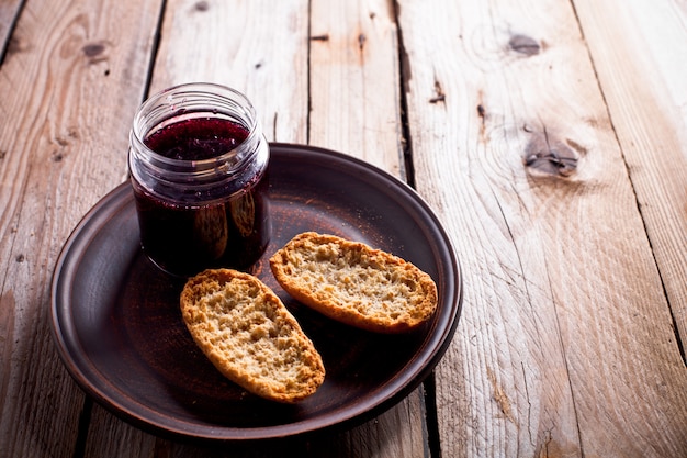 Marmellata di ribes nero in vaso di vetro e cracker