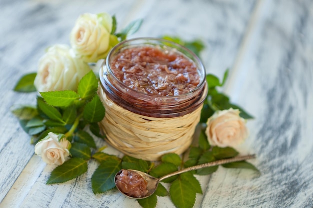 Marmellata rosa con petali di rosa Marmellata di petali di rosa in un barattolo di vetro su un tavolo da cucina grigio neutro con spazio per le copie