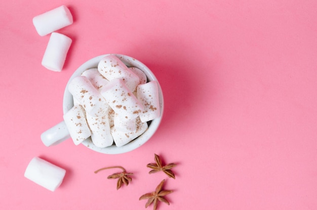 Marshmallow bianchi in una tazza di caffè su sfondo rosa brillante Spezie speziate anice stellato Luogo per il testo