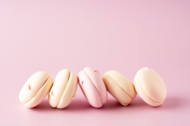 Marshmallow delicato rotondo su uno sfondo rosa, primo piano. Bellissimo sfondo di saluto in colori pastello. Bellissimi dolci, idee per una cartolina o una copertina.