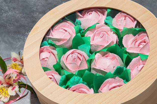 Marshmallow fatti a mano in confezioni di legno su sfondo chiaro con fiori. Il concetto delle feste Festa della donna e San Valentino. copia spazio.