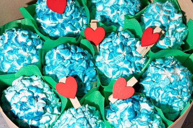 Marshmallow fatti a mano in confezioni di legno su sfondo chiaro con fiori. Il concetto delle feste Festa della donna e San Valentino. copia spazio.