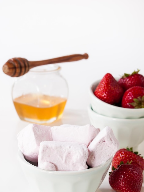 Marshmallow gourmet alla fragola su sfondo bianco.