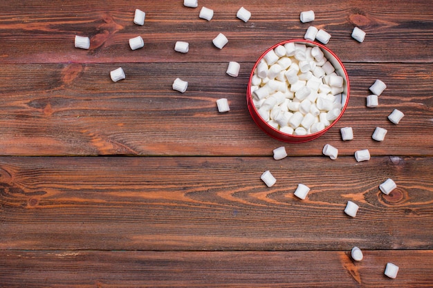 Marshmallow in una scatola su uno sfondo di legno