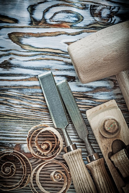 Martello di legno scalpelli pialla trucioli arricciati su tavola di legno