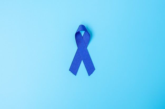 Marzo mese della consapevolezza del cancro del colon-retto, nastro di colore blu scuro per sostenere le persone che vivono e le malattie. Sanità, speranza e concetto di giornata mondiale del cancro