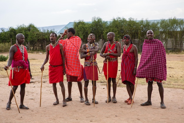 Masai in abiti tradizionali colorati che mostrano la danza del salto Maasai nel villaggio della tribù locale