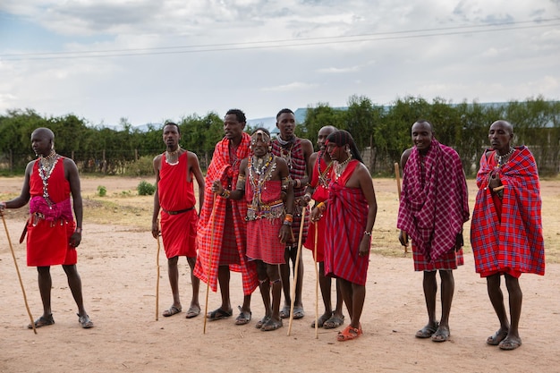 Masai in abiti tradizionali colorati che mostrano la danza del salto Maasai nel villaggio della tribù locale