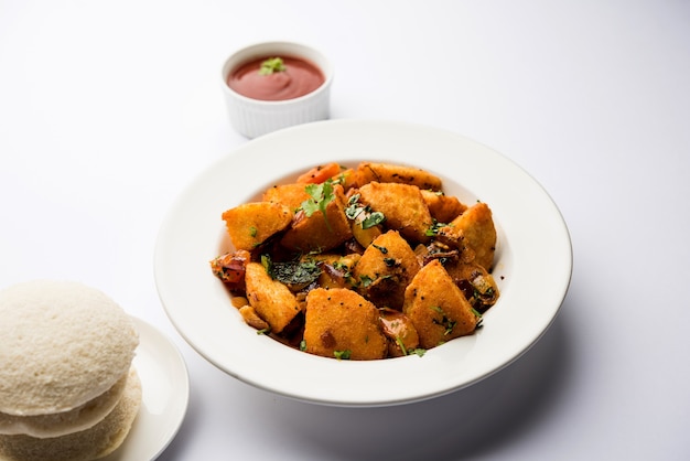 Masala fritto Idlies - merenda dell'India meridionale fatta con gli avanzi serviti pigramente con ketchup di pomodoro. messa a fuoco selettiva