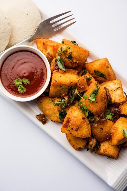 Masala fritto Idlies - merenda dell'India meridionale fatta con gli avanzi serviti pigramente con ketchup di pomodoro. messa a fuoco selettiva