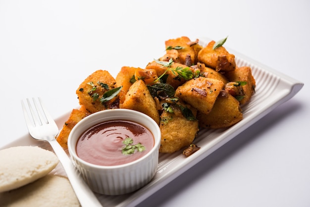 Masala fritto Idlies - merenda dell'India meridionale fatta con gli avanzi serviti pigramente con ketchup di pomodoro. messa a fuoco selettiva