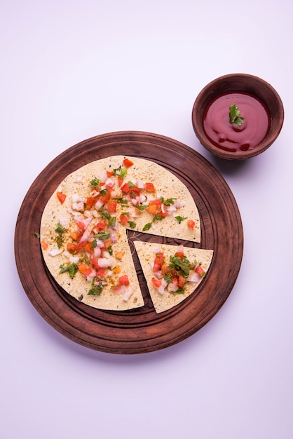 Masala papad è un alimento o antipasto croccante vegetariano indiano che è molto facile da preparare. Servito con ketchup su sfondo lunatico. Messa a fuoco selettiva