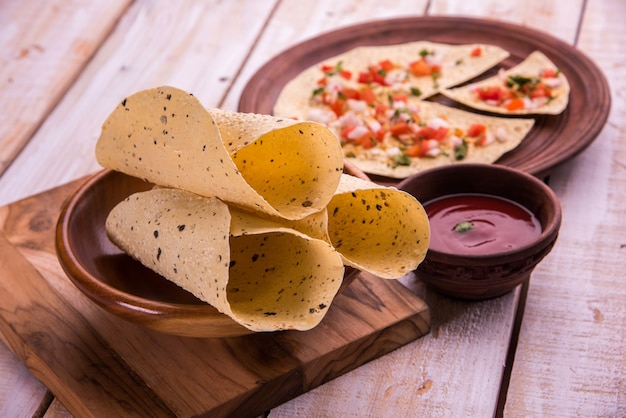 Masala papad è un alimento o antipasto croccante vegetariano indiano che è molto facile da preparare. Servito con ketchup su sfondo lunatico. Messa a fuoco selettiva