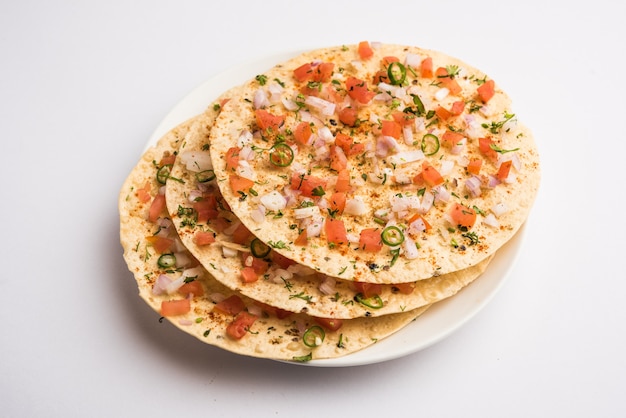 Masala Papad orÃ‚Â papadumÃ‚Â è un delizioso spuntino indiano fatto con papad arrostito o fritto condito con un mix piccante e piccante di pomodoro cipolla