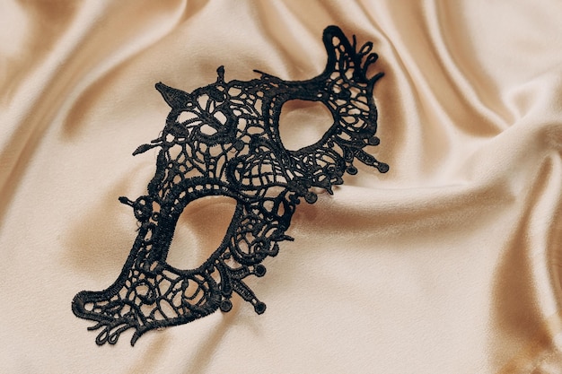 Maschera da travestimento elegante in pizzo nero sexy su lenzuolo di seta dorata