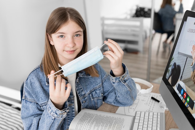 Maschera della holding della ragazza del colpo medio