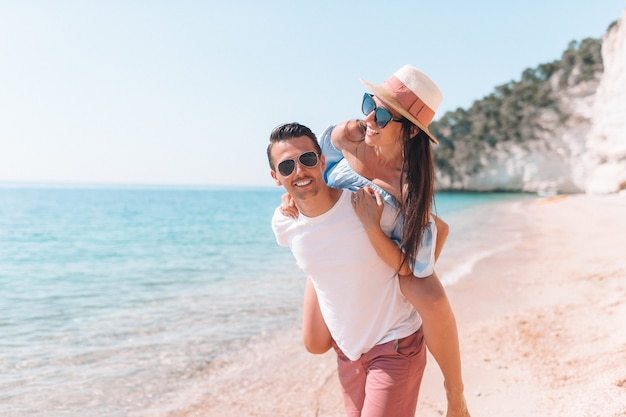 Maschera delle coppie felici in occhiali da sole sulla spiaggia