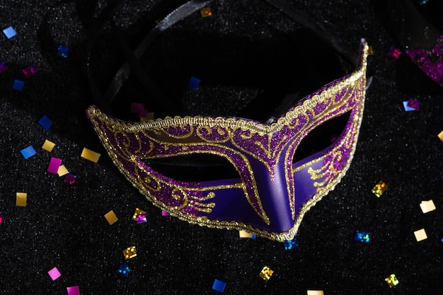 Maschera di carnevale con confetti su sfondo nero