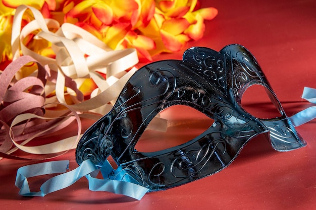 Maschera di carnevale veneziano con piume ed elementi tipici sullo sfondo