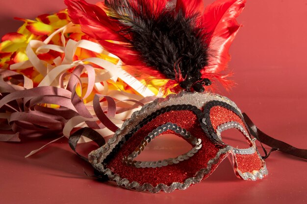 Maschera di carnevale veneziano con piume ed elementi tipici sullo sfondo