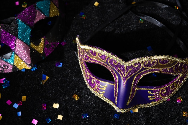 Maschera di mascherata con confetti su sfondo nero